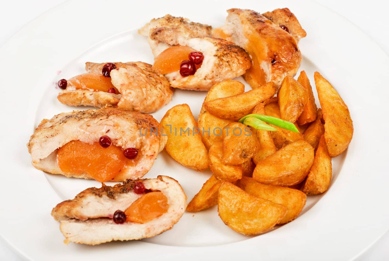 Roast chicken meat with apricot and potato closeup