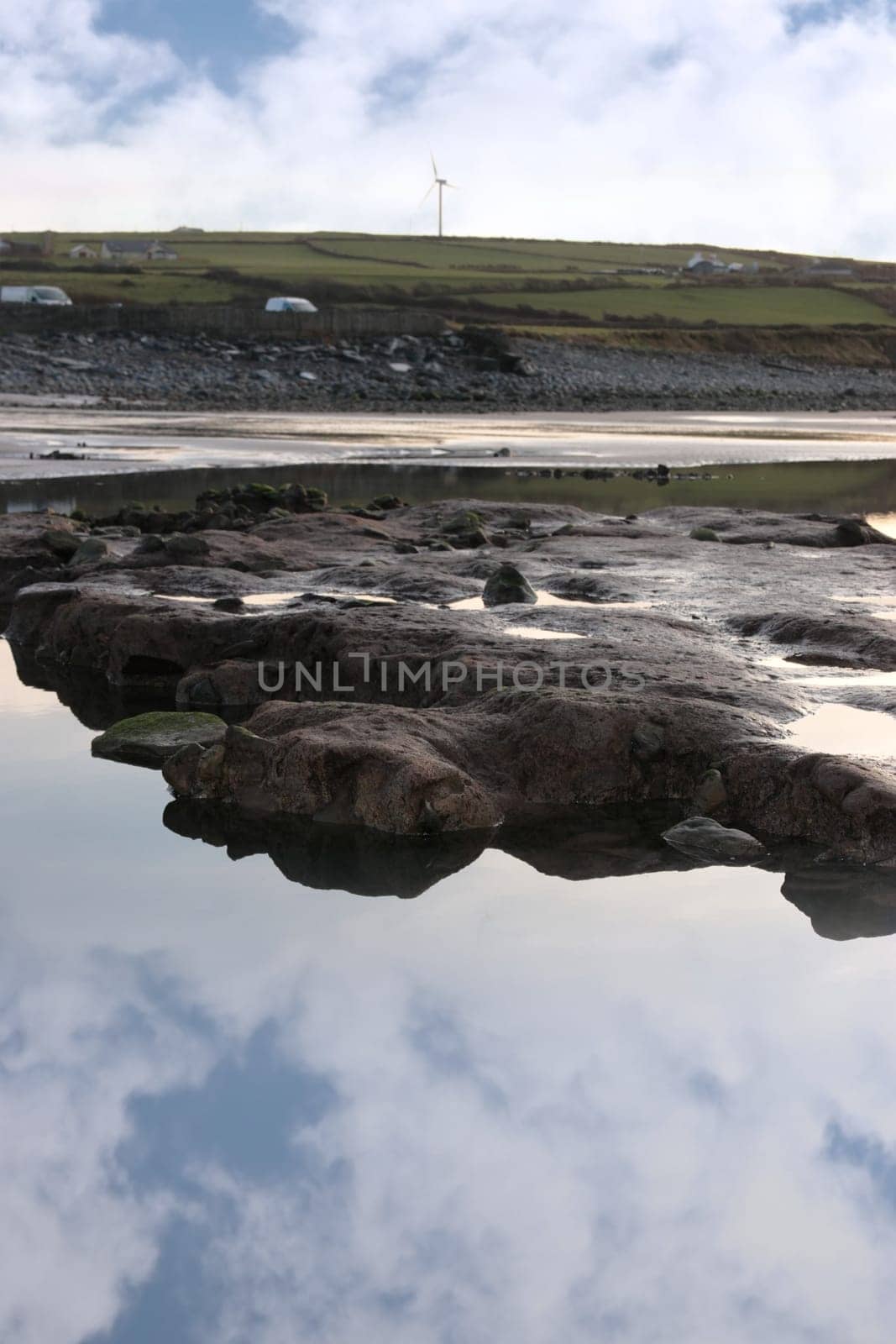 rock pool on beale beach co kerry ireland on a cold winters morning with turbine in the background