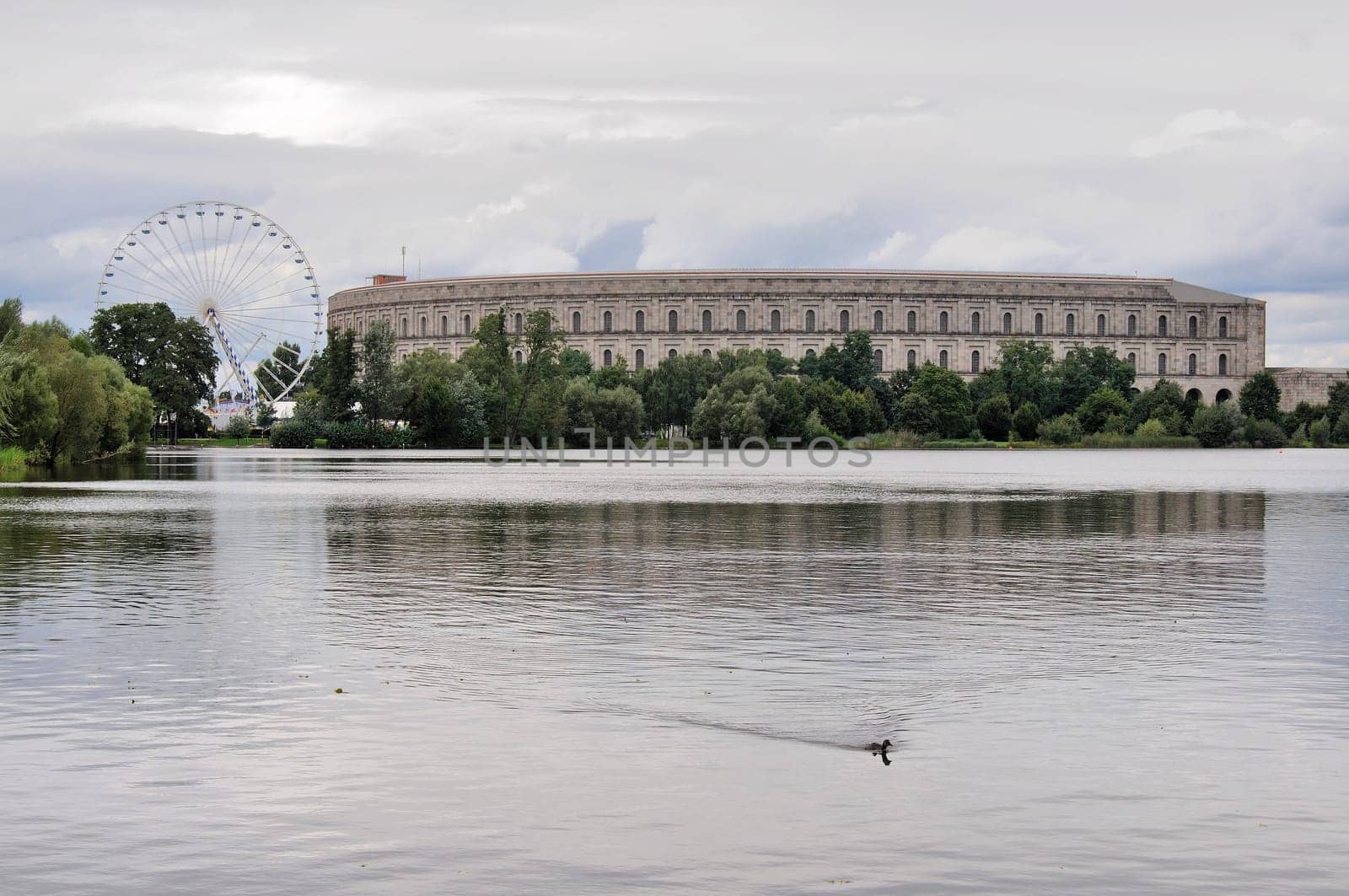 view of remains of nazi congress hall reflecting in lake under thunderclouds