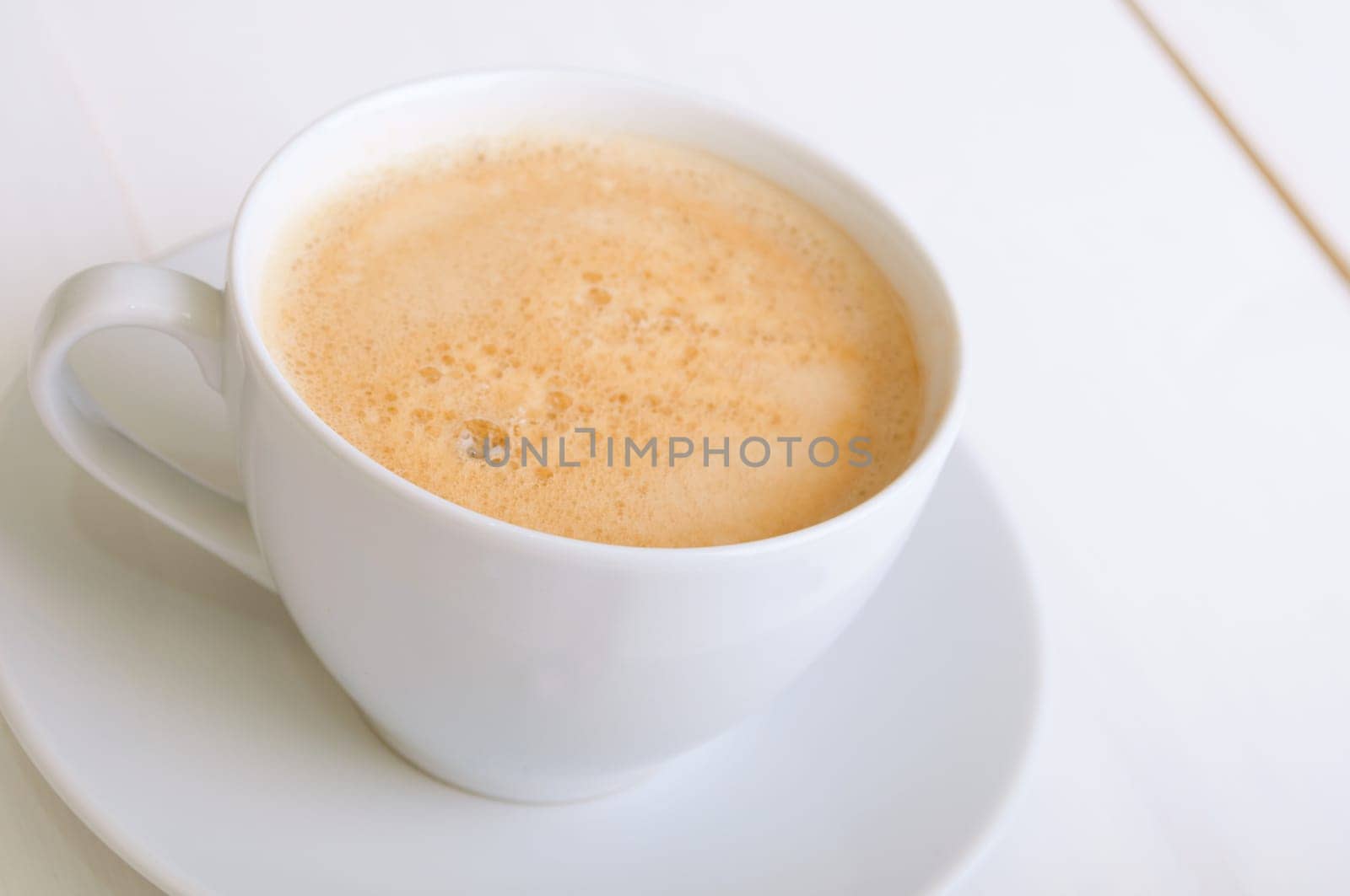 Creamy Espresso Coffee in White Cup on Table