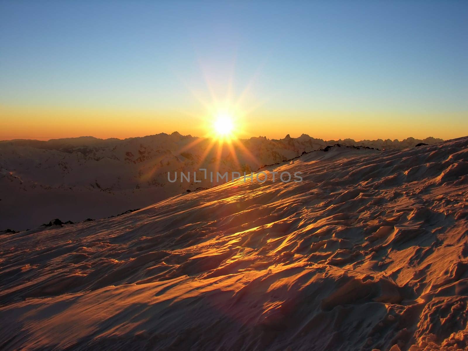 Sunset in snow-covered mountains of Caucasus