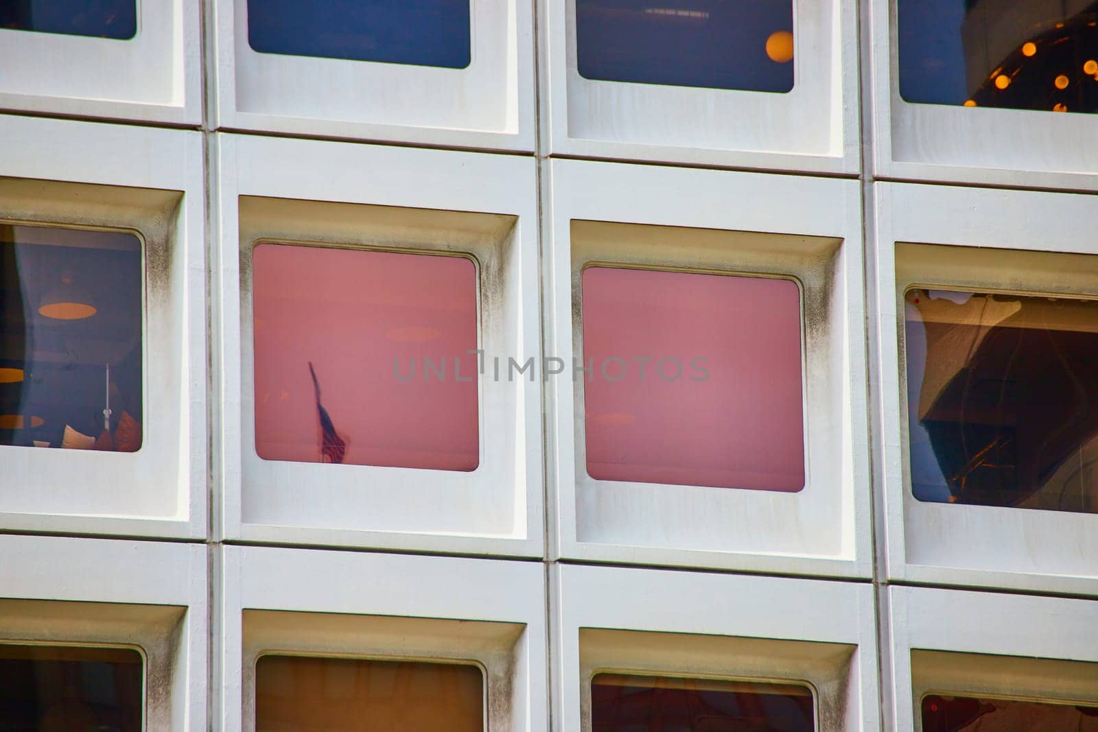 Image of Close up of square windows with pink lighting and reflected American flag