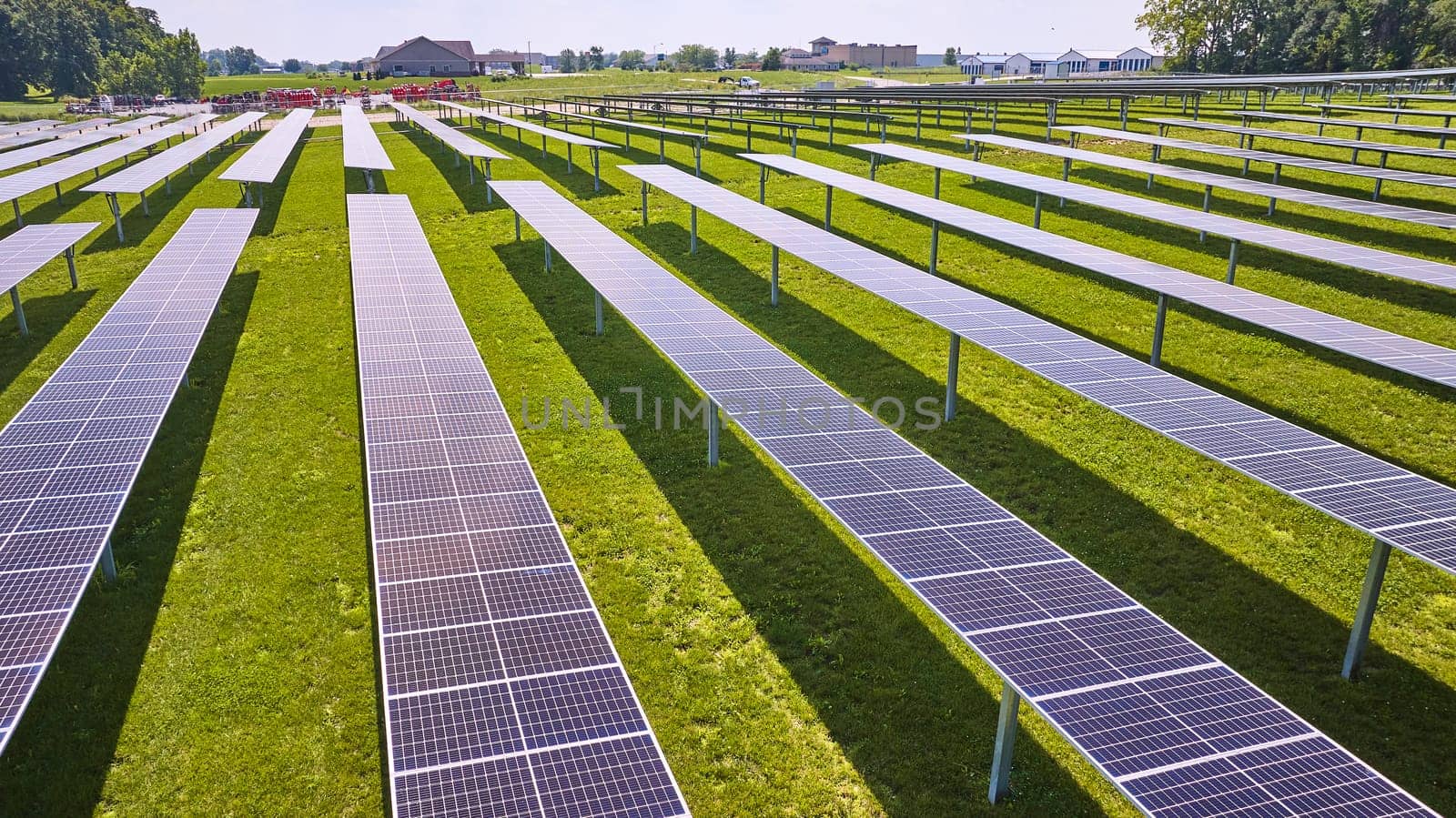 Image of Sunlight hitting solar panels on solar farm in low flying aerial
