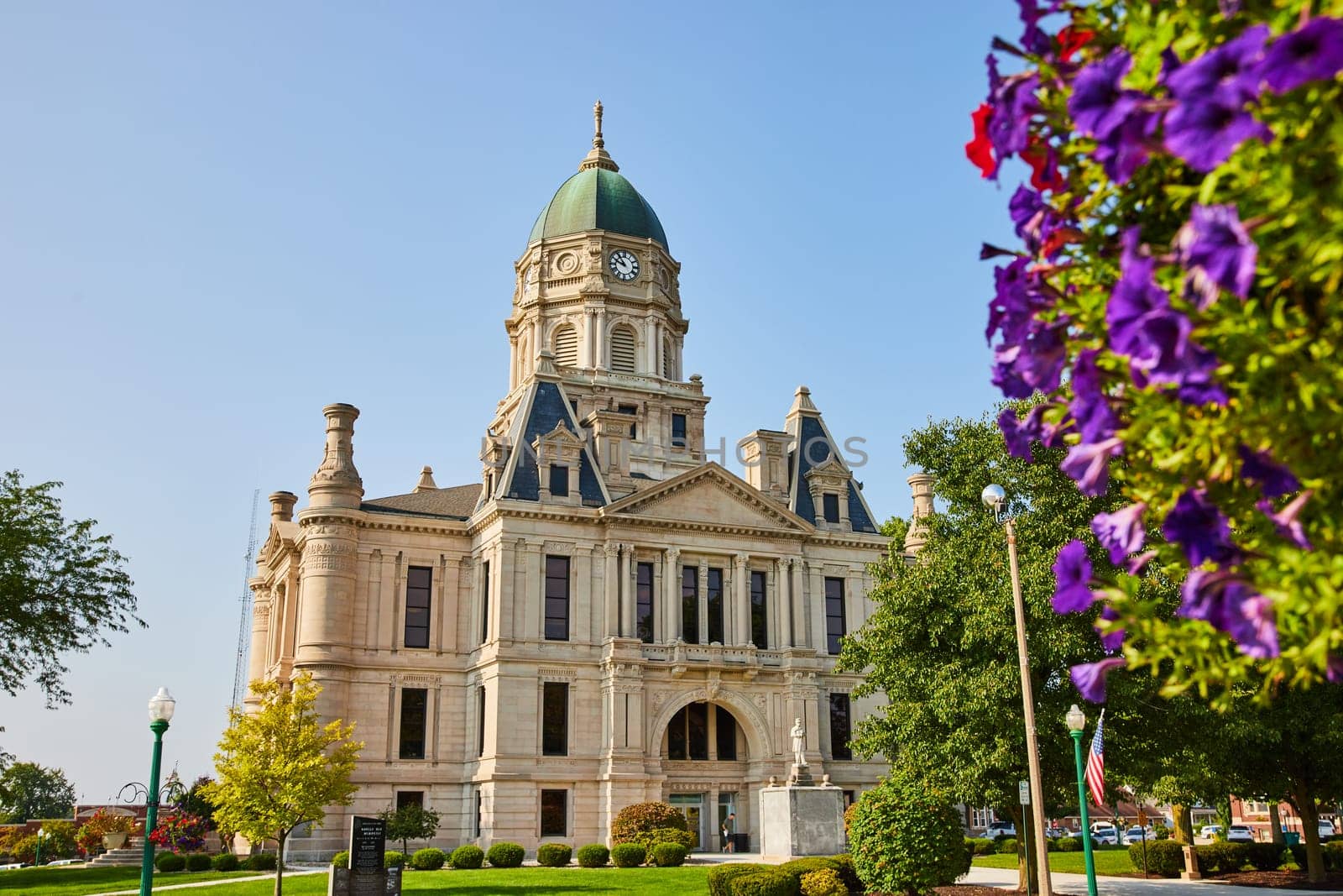 Image of Columbia city courthouse with red and purple flowers on side of shot on sunny day