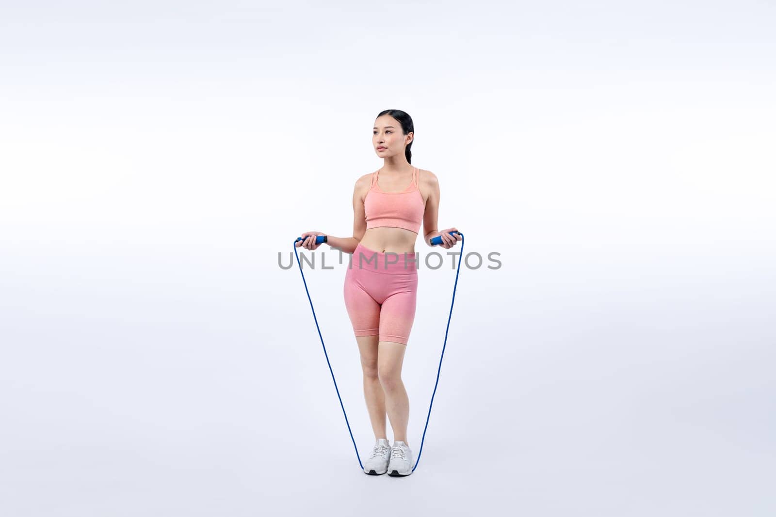 Young energetic asian woman in sportswear with jumping rope. Vigorous by biancoblue