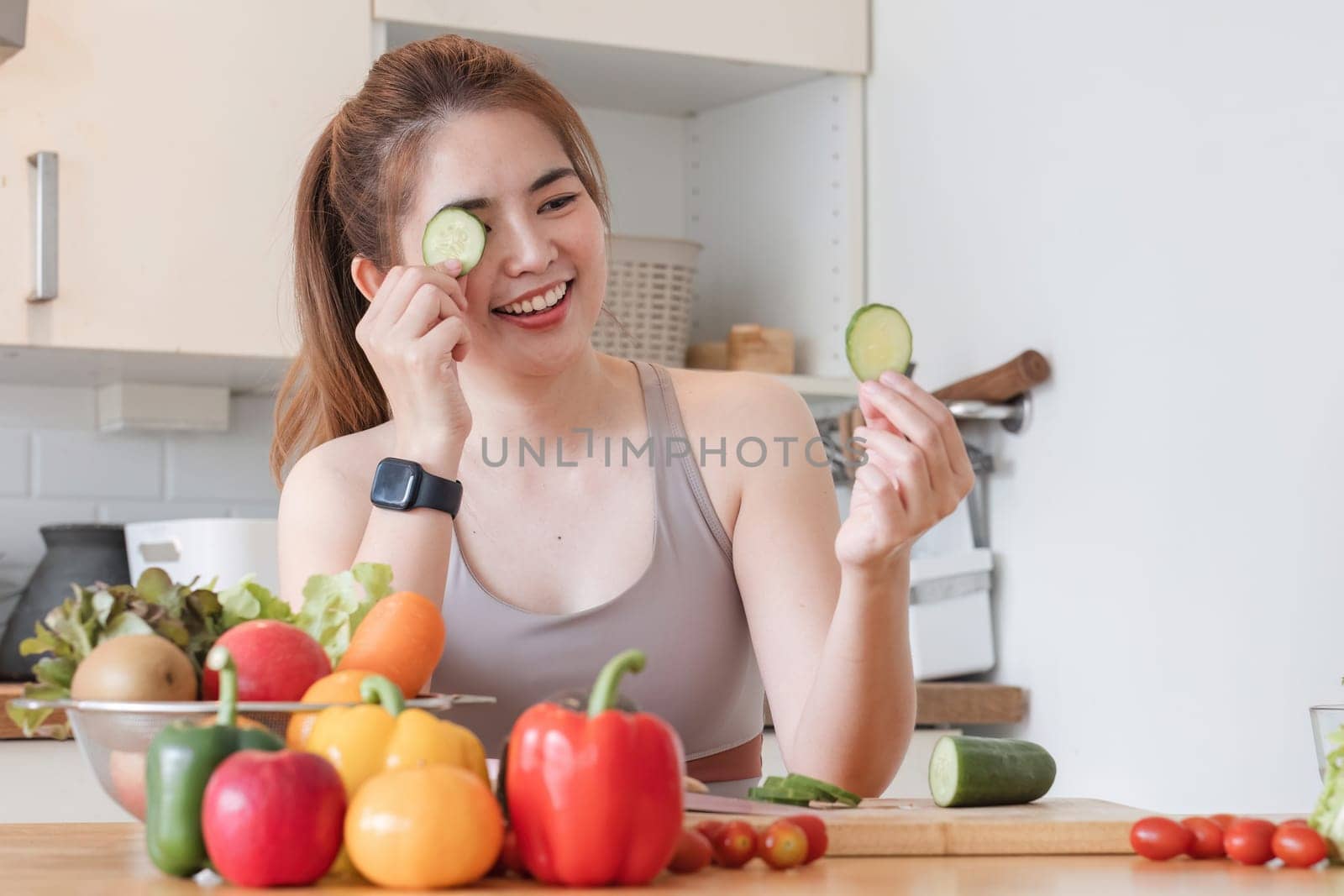 Sporty young woman is preparing healthy food on light kitchen. healthy food concept. by wichayada