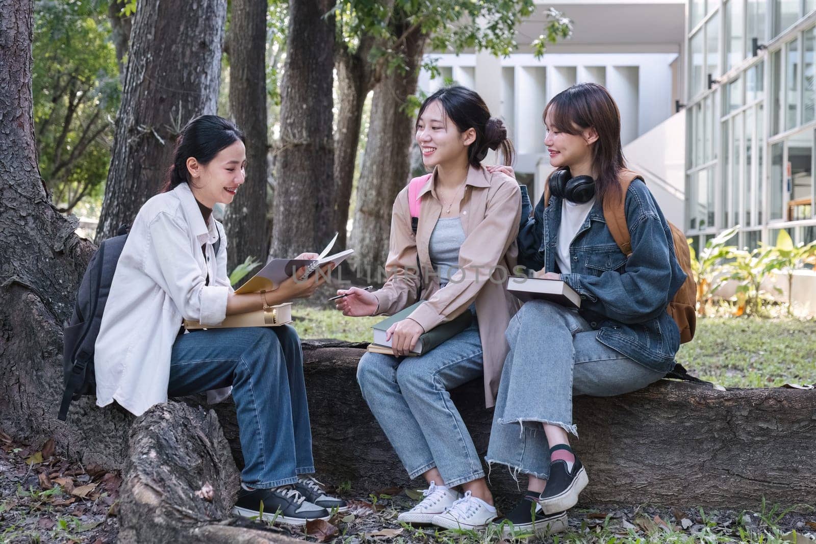 Group of cheerful Asian college students or friends laughing together while sitting in university..