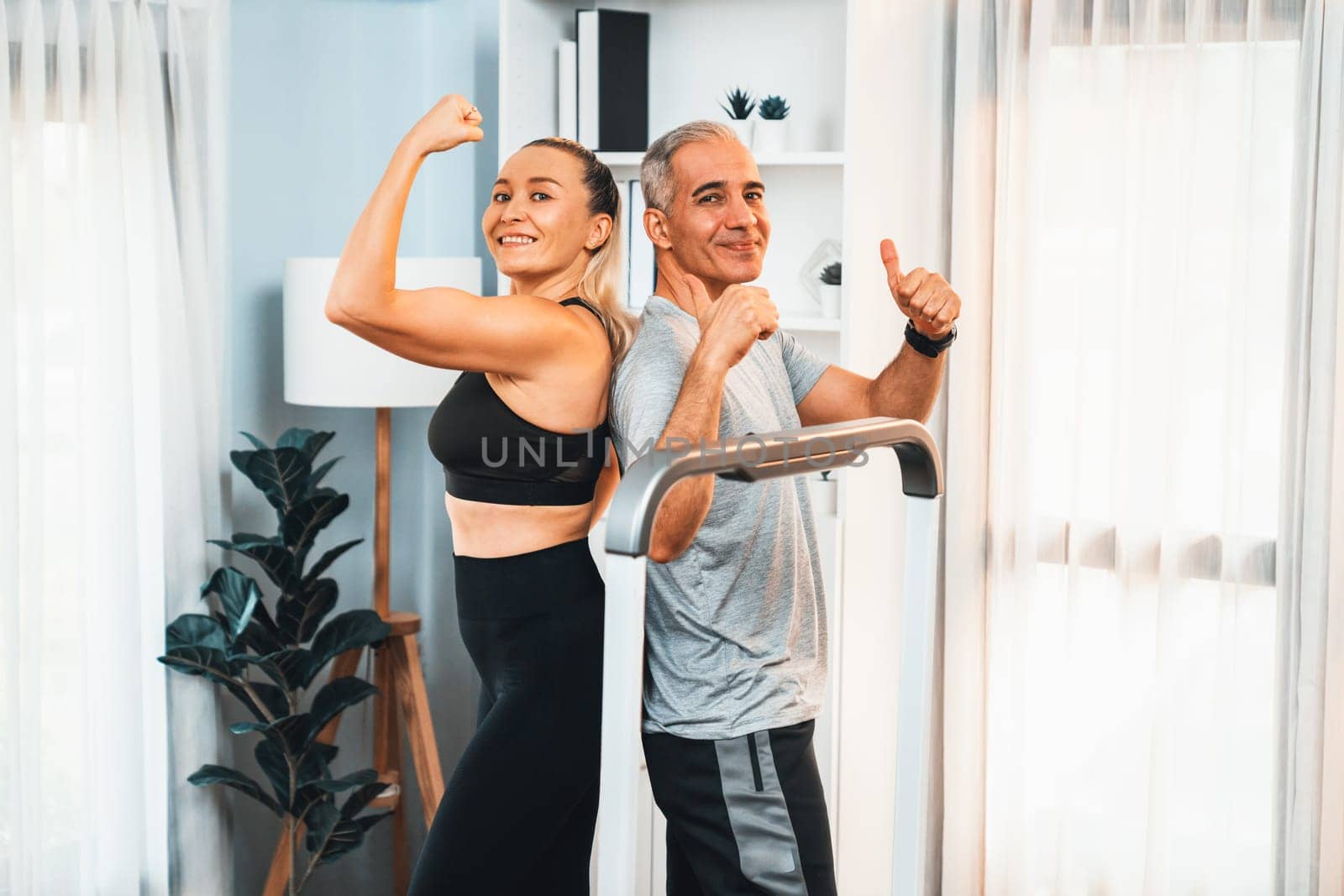 Athletic and sporty senior couple portrait in sportswear with successful or celebrating after overcome struggle posture as home exercise concept with healthy fit body lifestyle after retirement. Clout