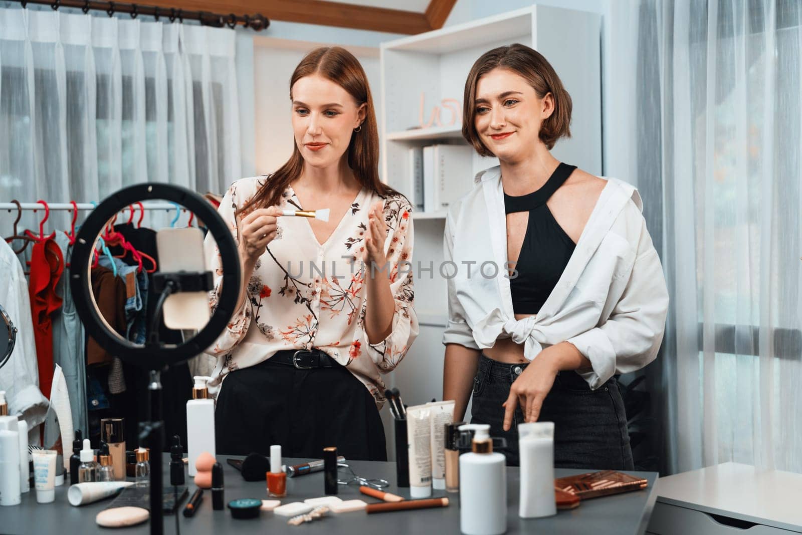 Woman influencer shoot live streaming vlog video review makeup utmost social media or blog. Happy young girl with cosmetics studio lighting for marketing recording session broadcasting online.