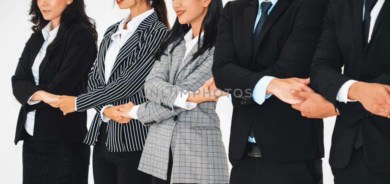 Successful business people standing together showing strong relationship of worker community. A team of businessman and businesswoman expressing a strong group teamwork at the modern office. Jivy