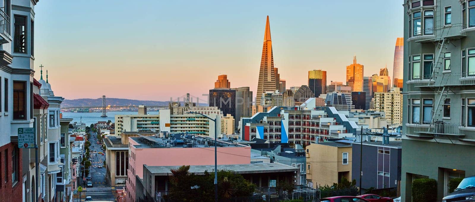 Image of Panorama San Francisco downtown city and skyscrapers at sunset with Oakland Bay Bridge behind