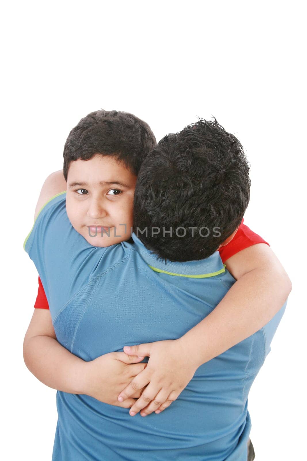 Portrait of a young boy hugging his father against white background