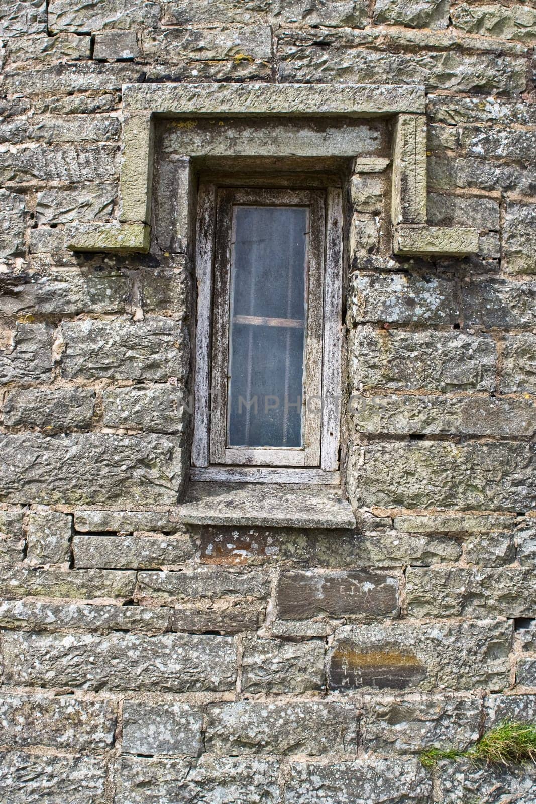An old brick building with a crooked window
