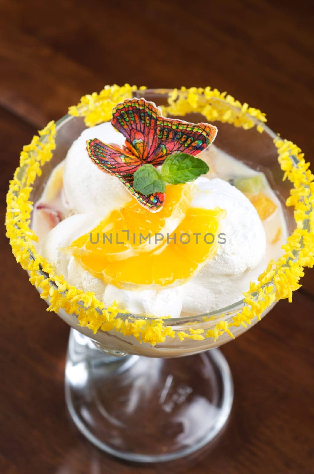 Ice cream dessert with kiwi and orange decorated with butterfly