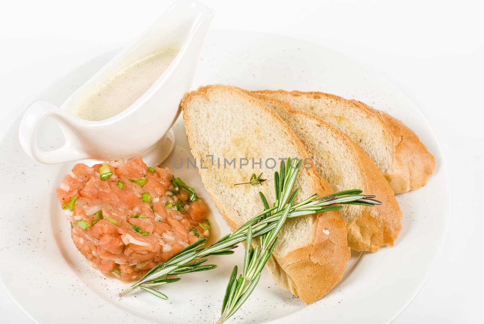Tar-tar from salmon fish with green onion. Served with honey sauce and white bread toast.
