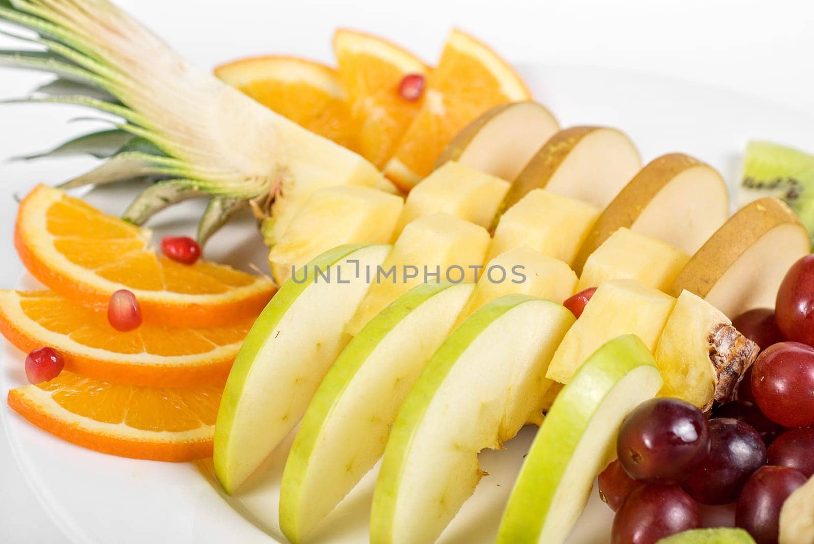Fruit assortment closeup at plate on a white background