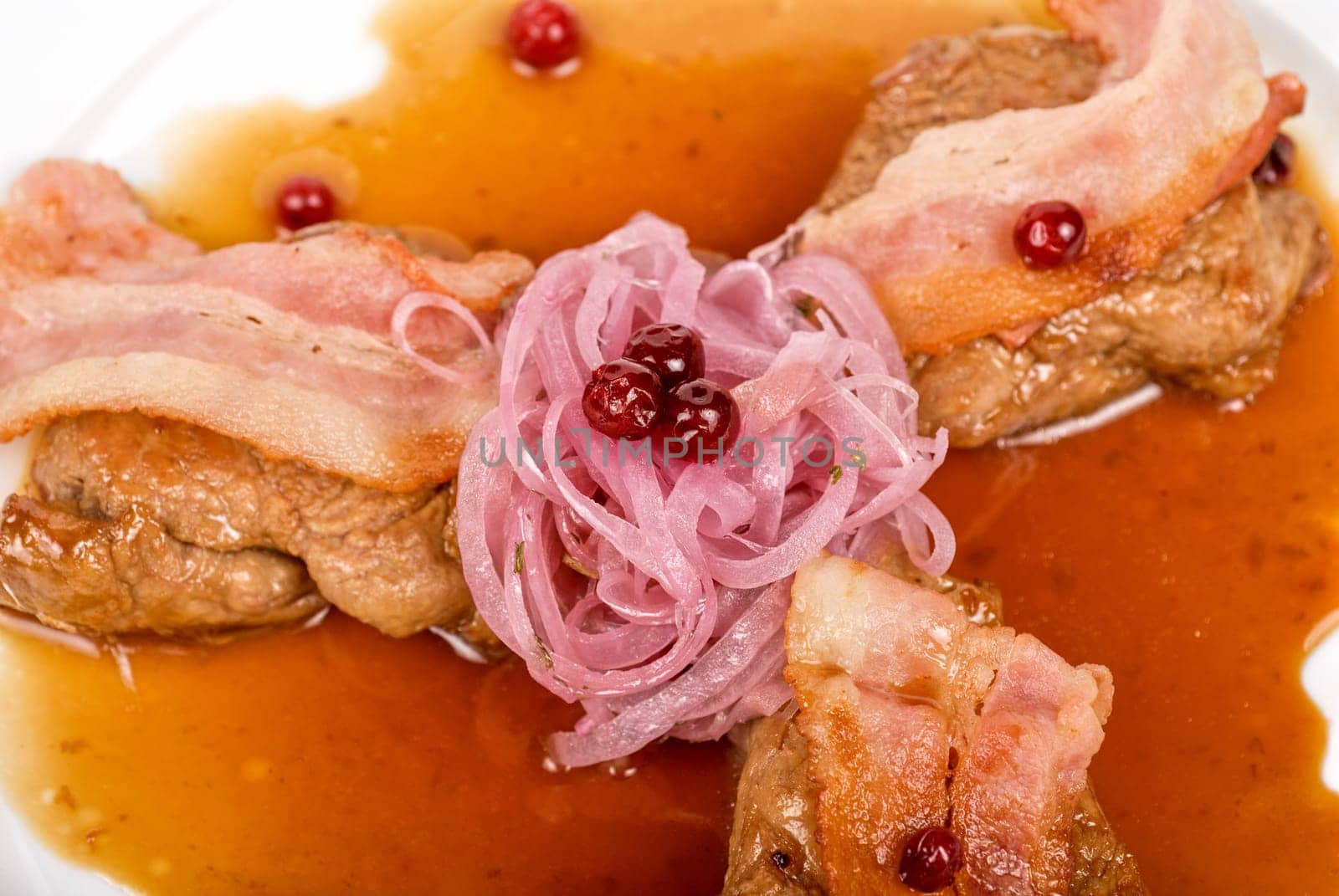 Roast pork meat with bacon, onion and cranberries