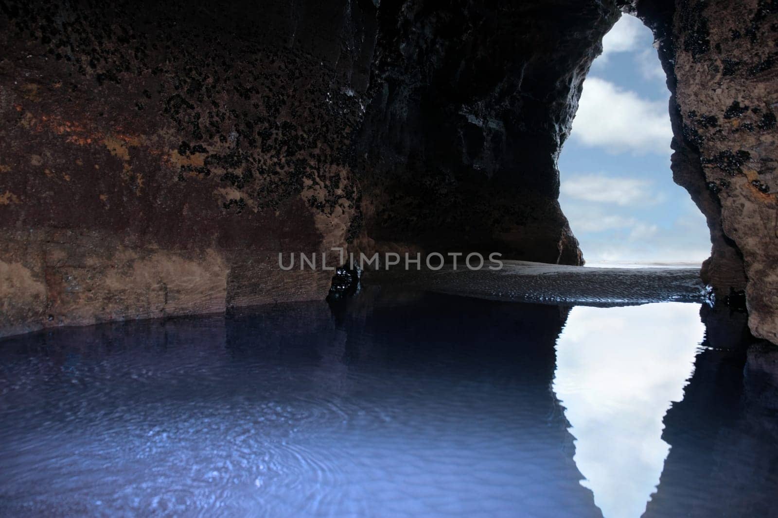 a view from the inside of a beach cave looking out at the sea
