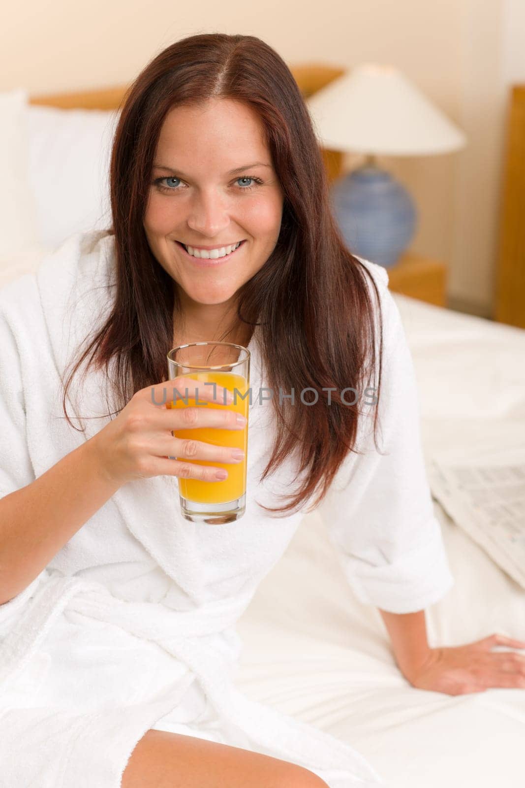 Breakfast - Smiling woman with fresh orange juice in white bedroom