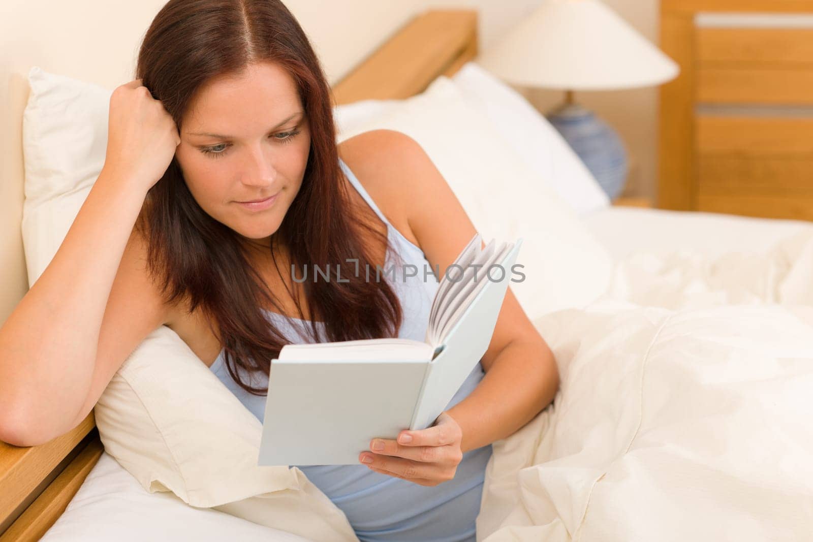 Bedroom - young woman read book in white bed