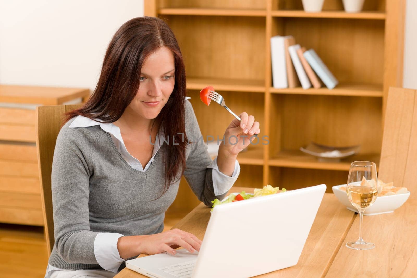 Working lunch at home attractive woman with laptop eat salad