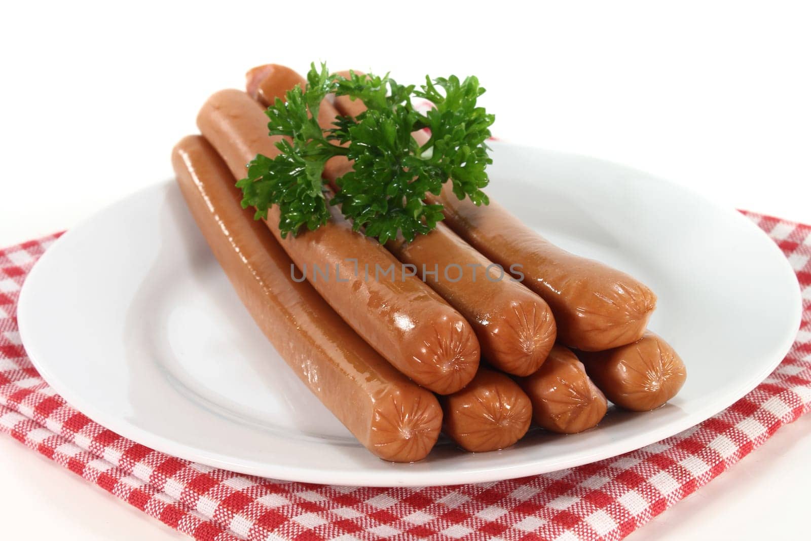 Viennese sausages and parsley on a white plate