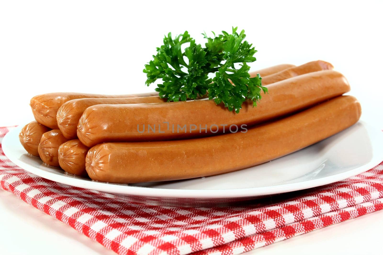 Viennese sausages and parsley on a white plate