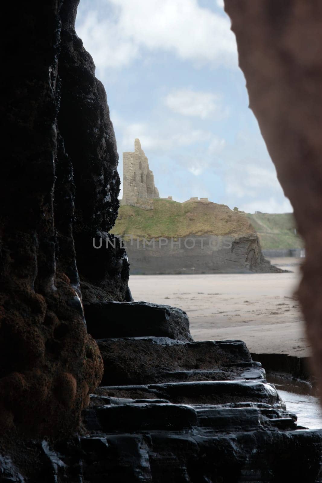 a view of ballybunion castle as seen from a cliff cave