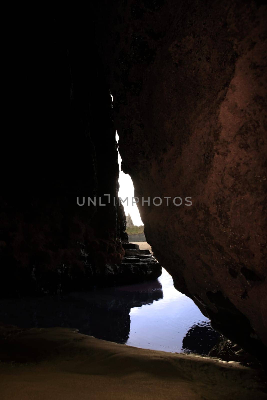 a view of ballybunion castle as seen from a cliff cave
