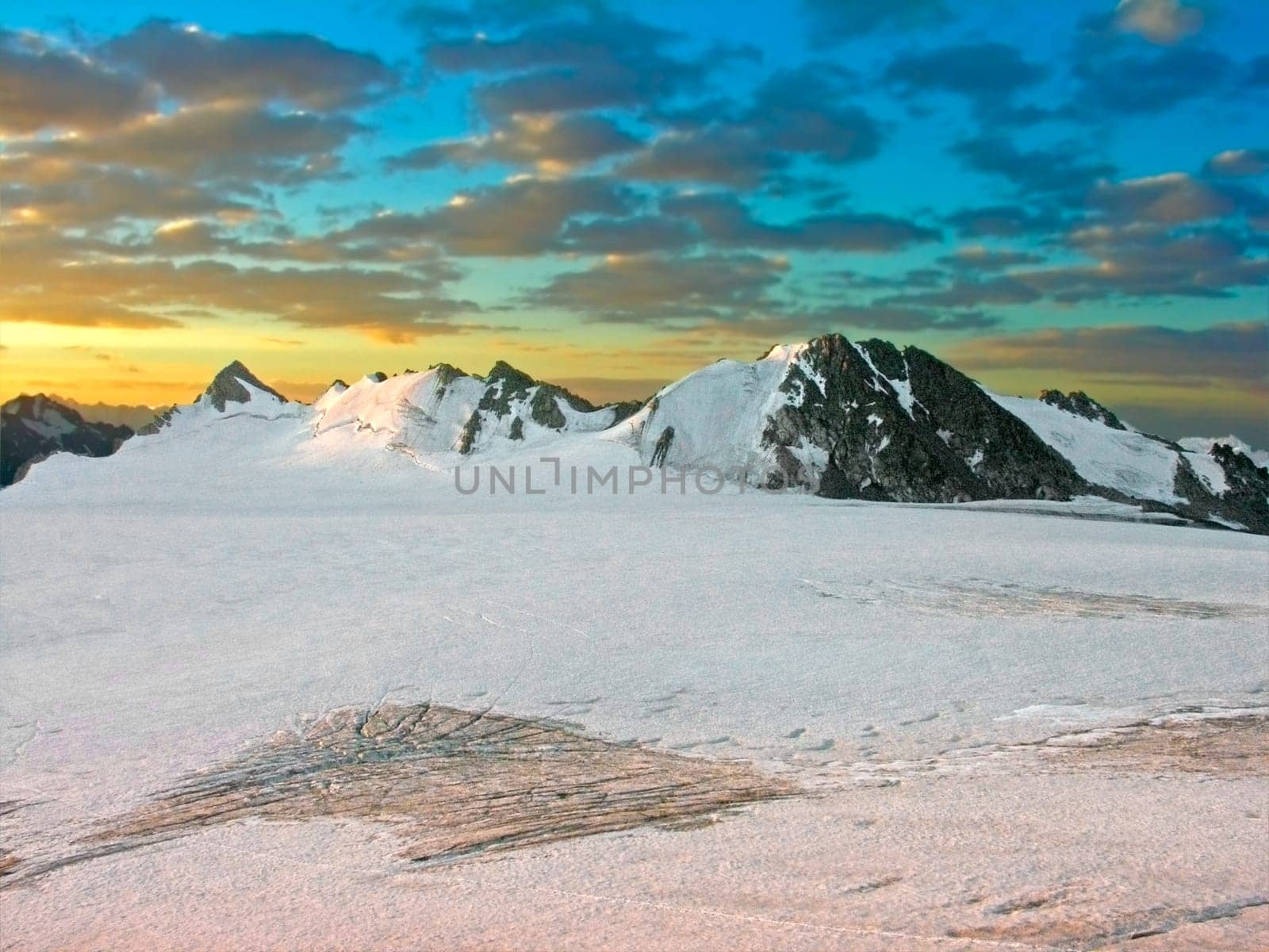 The snow-covered mountains lighted by a sunset