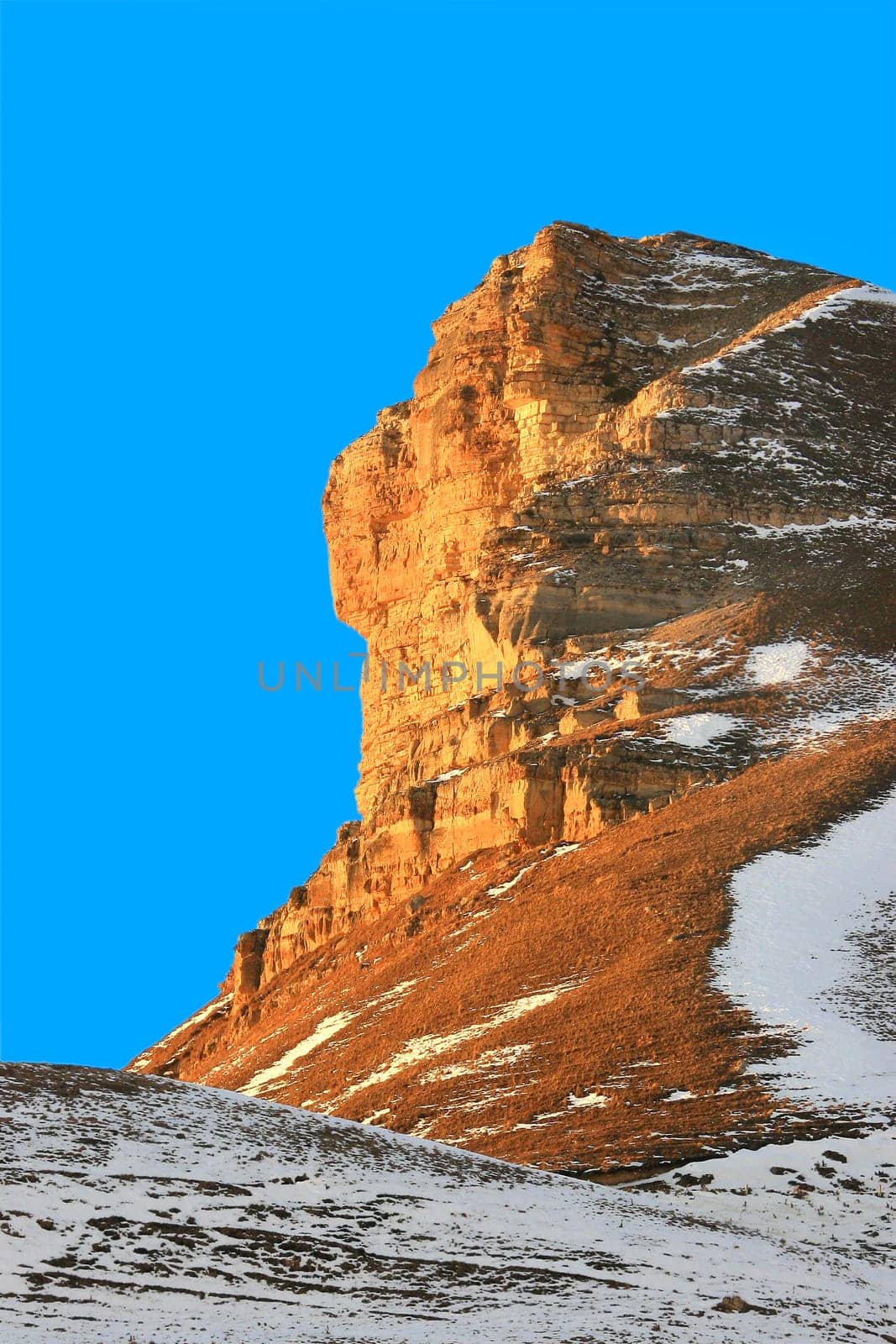 Red rock in a snow on a background of the blue sky