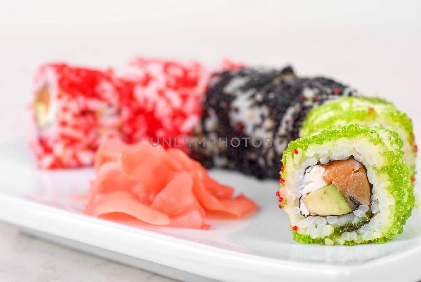 Sushi rolls made of fish avocado and different flying fish roe (tobiko caviar)