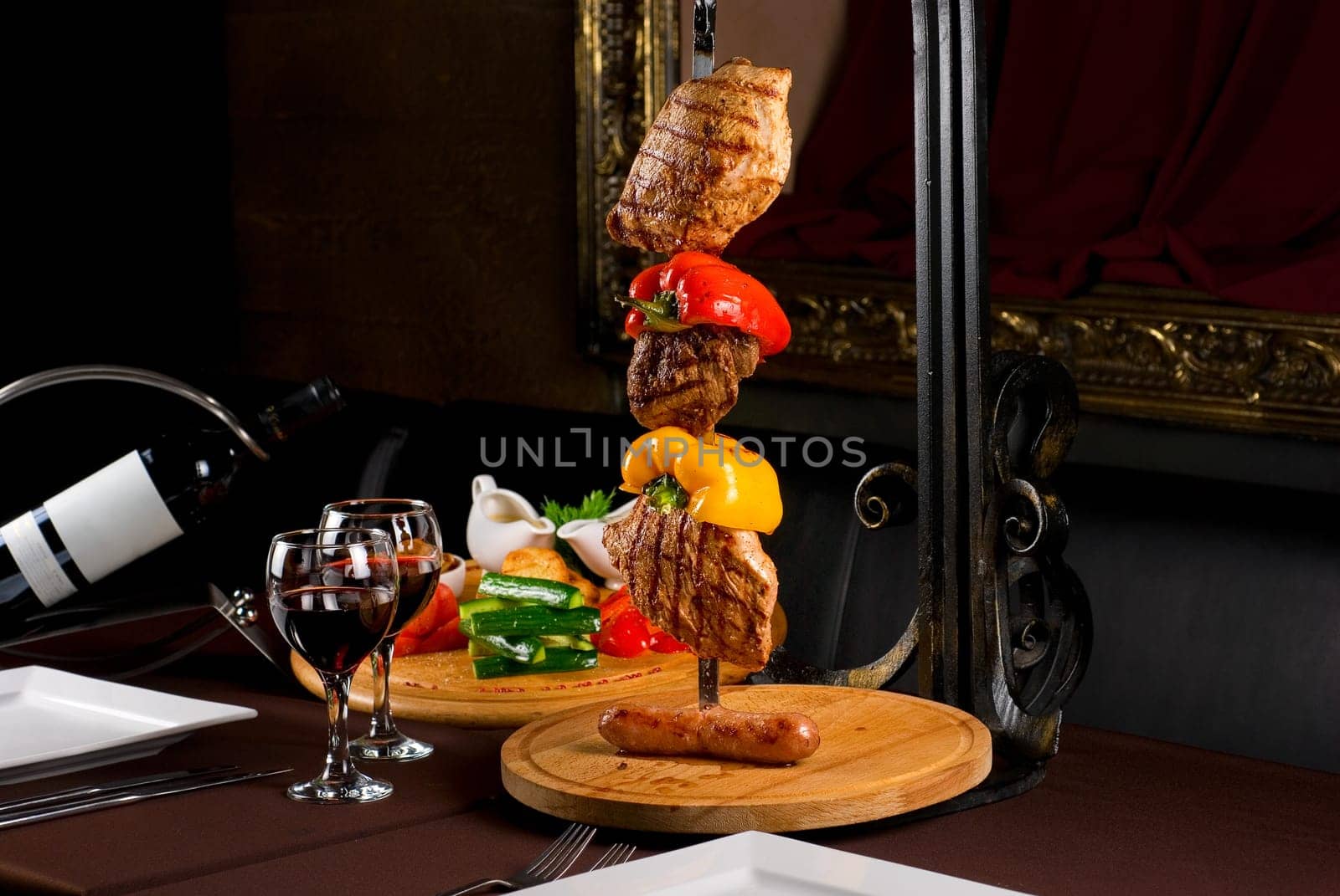 Big tasty roasted meat cuts at skewer on a decorated table