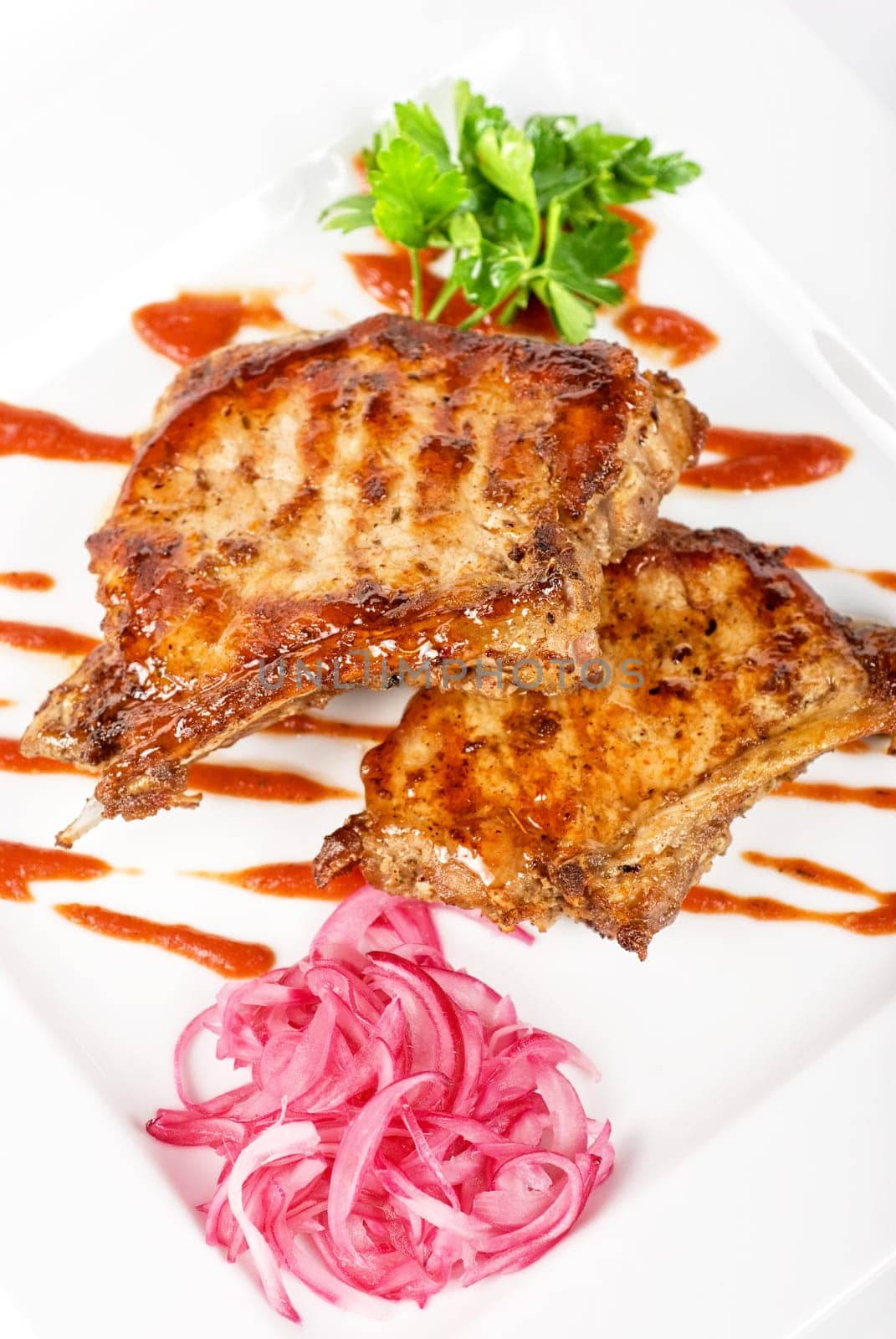 Roasted pork meat at plate with greens