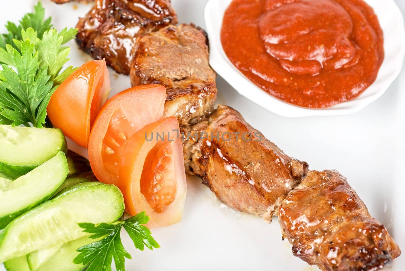Fried kebab meat with vegetables and sauce