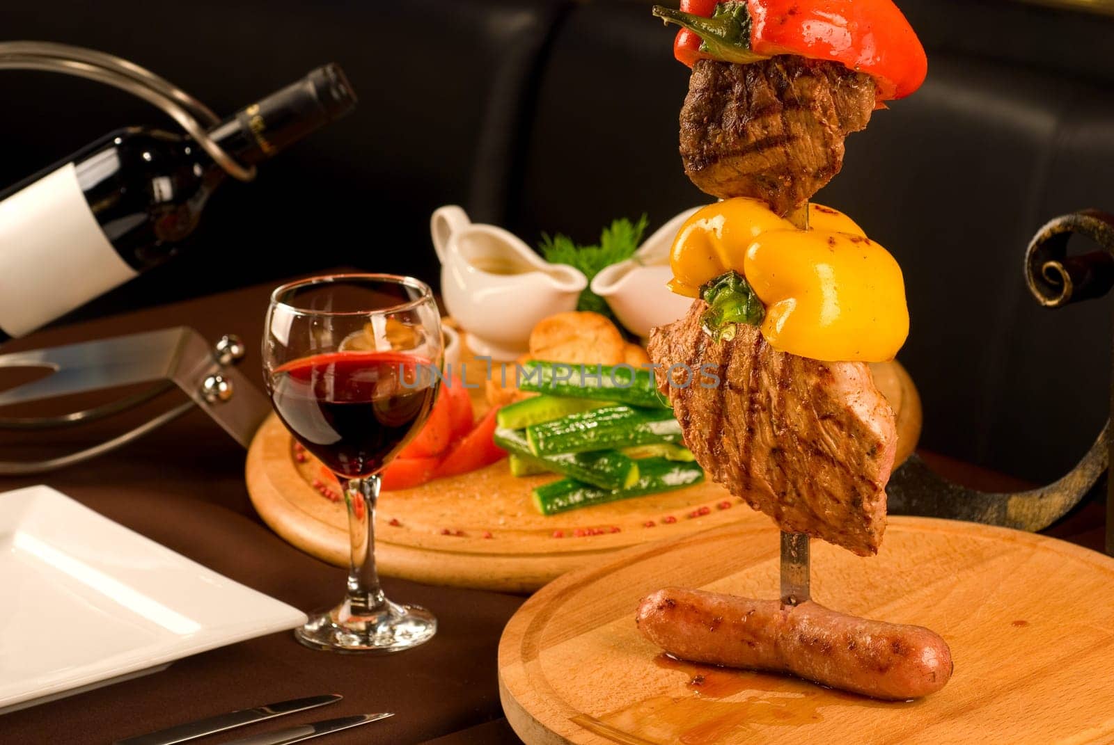 Big tasty roasted meat cuts at skewer on a decorated table