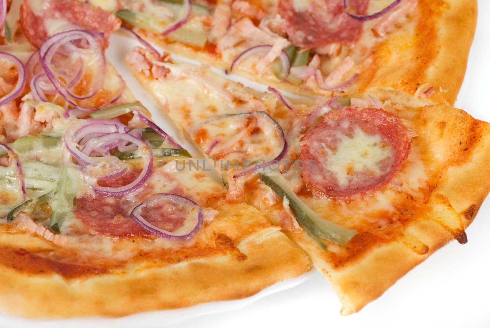 pizza closeup with smoked meat, salami, gherkin, onion and mozzarella cheese