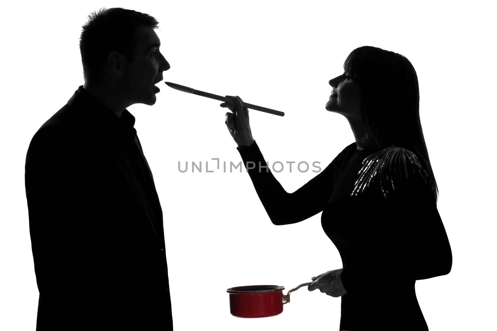 one caucasian couple man and woman tasting cooking sauce pan in studio silhouette isolated on white background