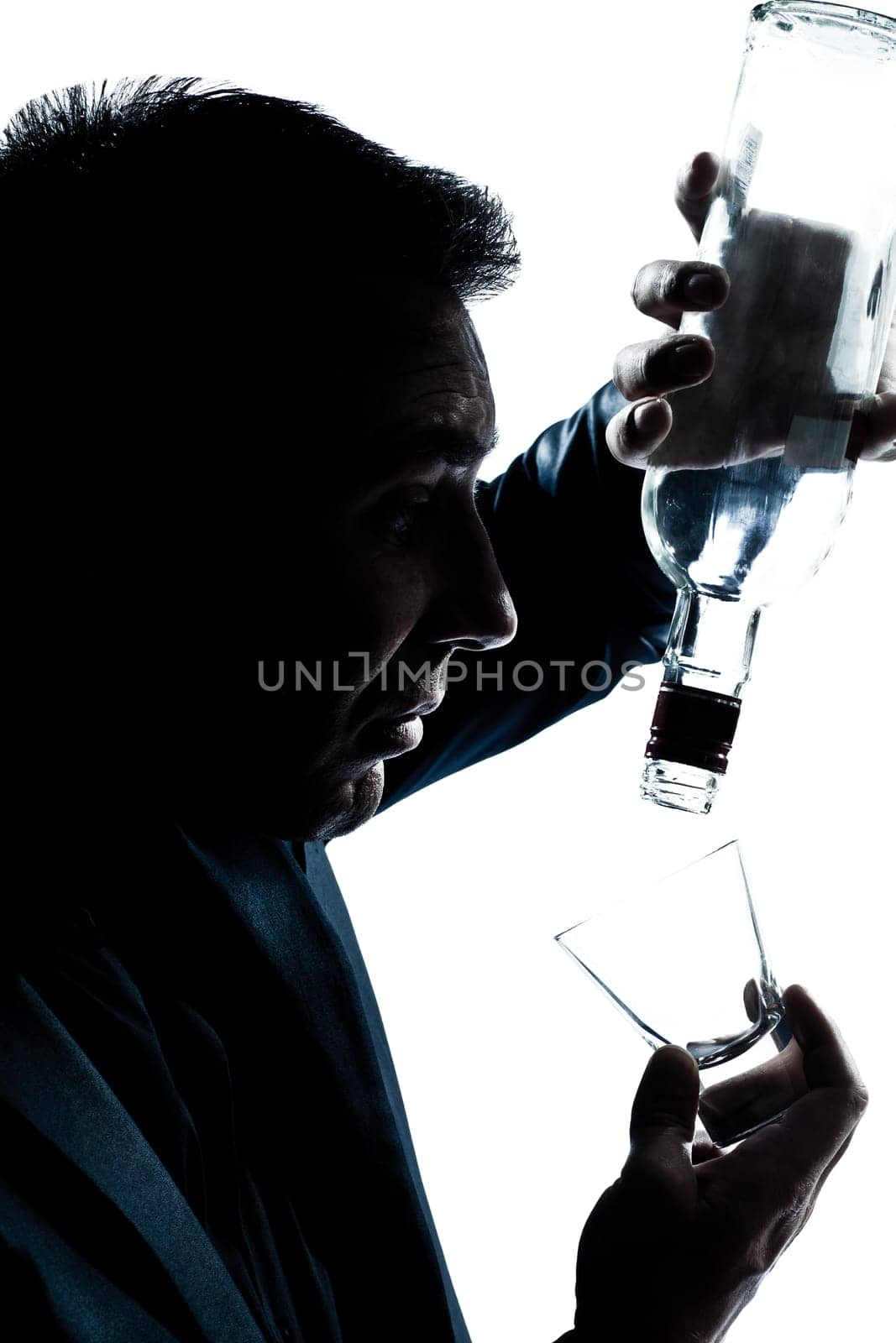 one caucasian man portrait silhouette drunk puring empty alcohol bottle in studio isolated white background