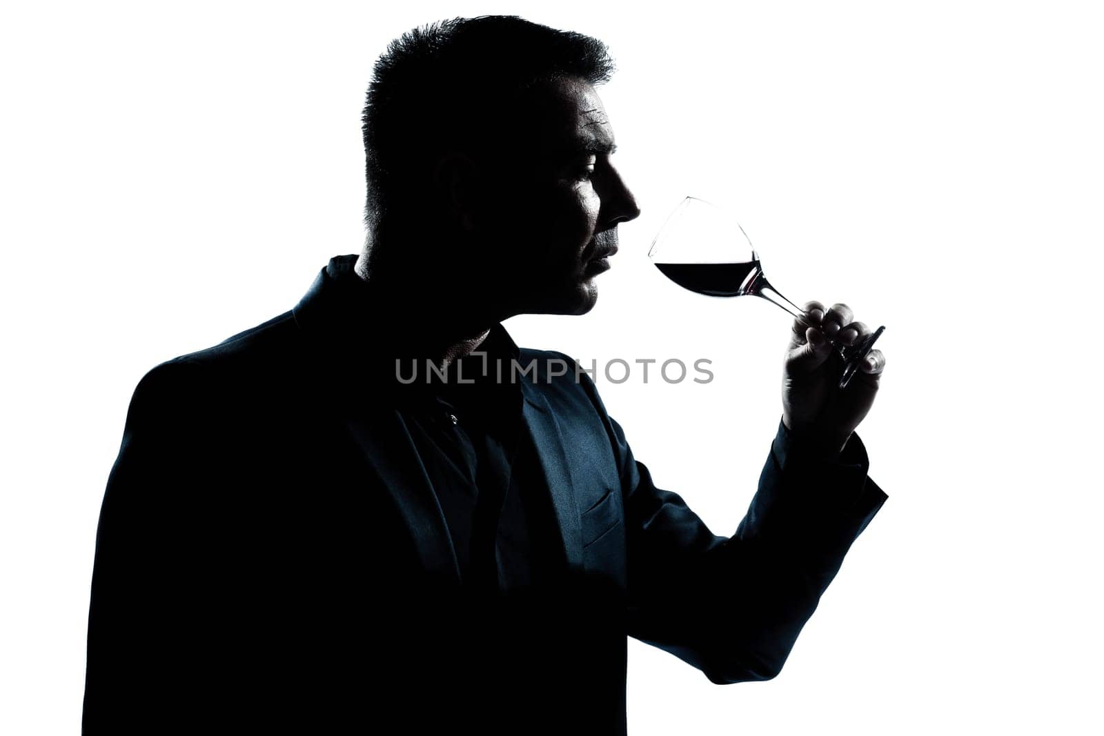 one caucasian man portrait silhouette smelling red wine glass in studio isolated white background