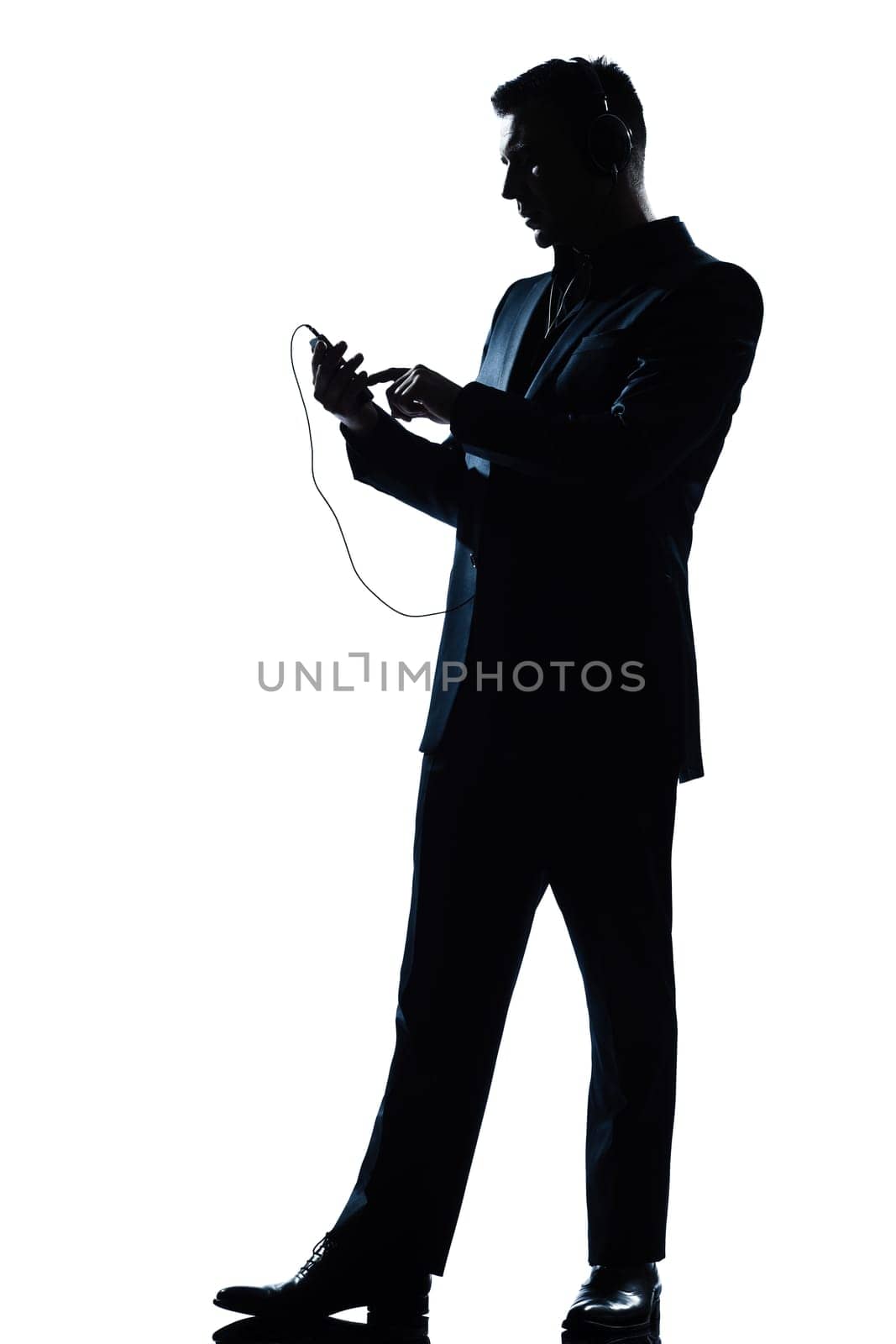 one caucasian man text messaging telephone listening to music full length silhouette in studio isolated white background