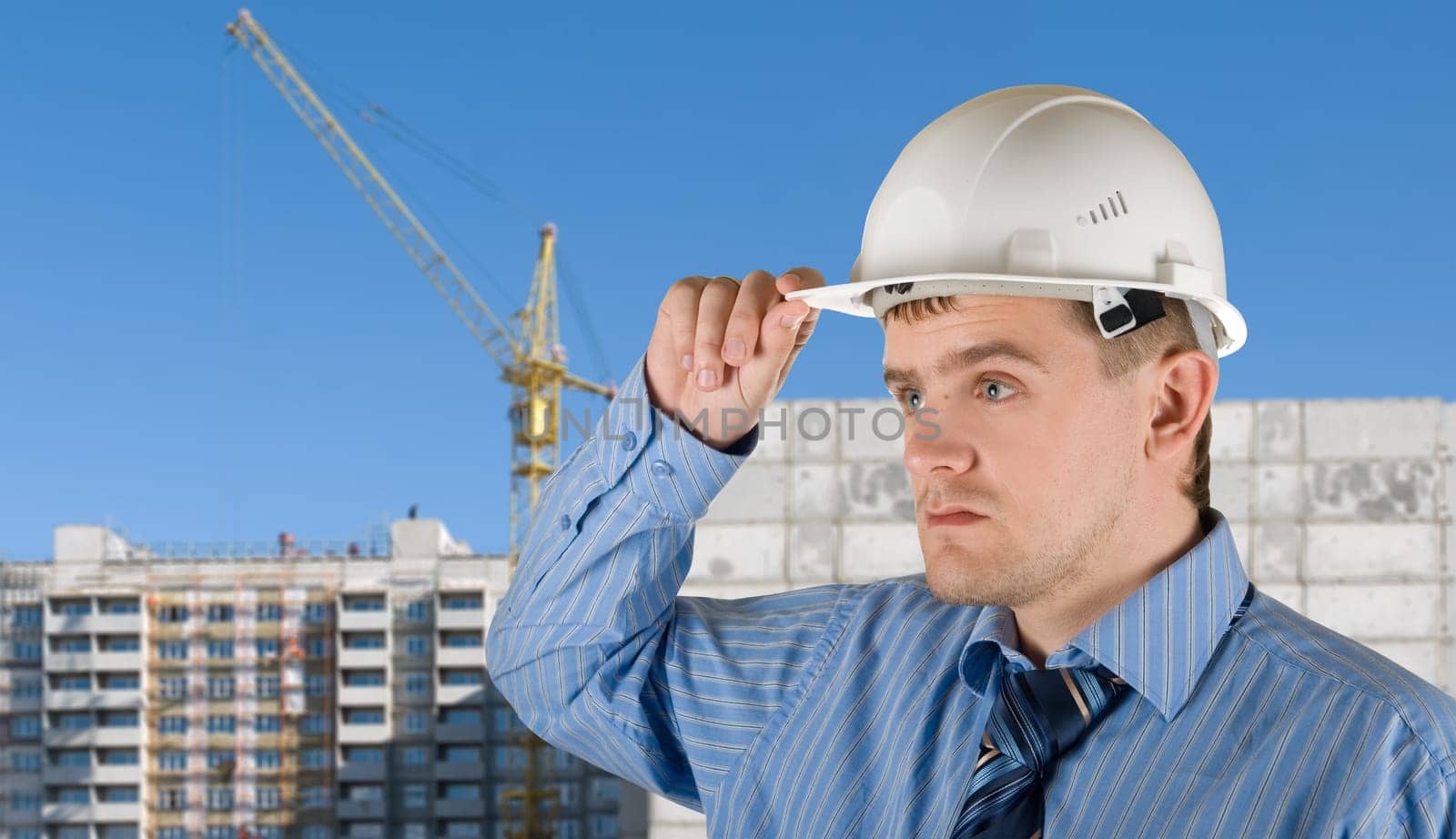 Engineer at white helmet on building background