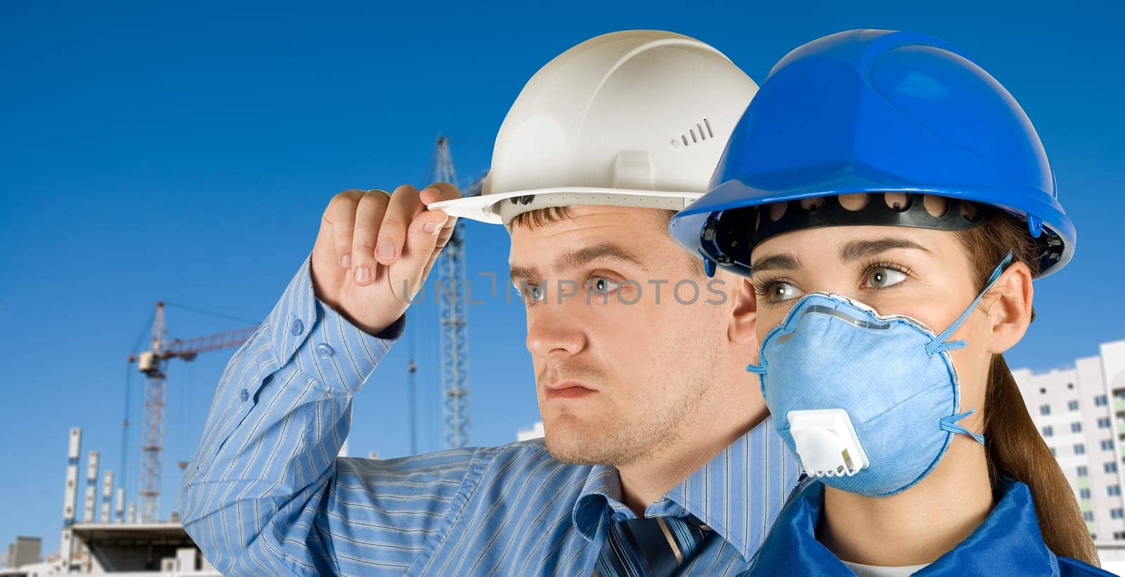 Portrait of young architects at in front of construction site, building and crane.