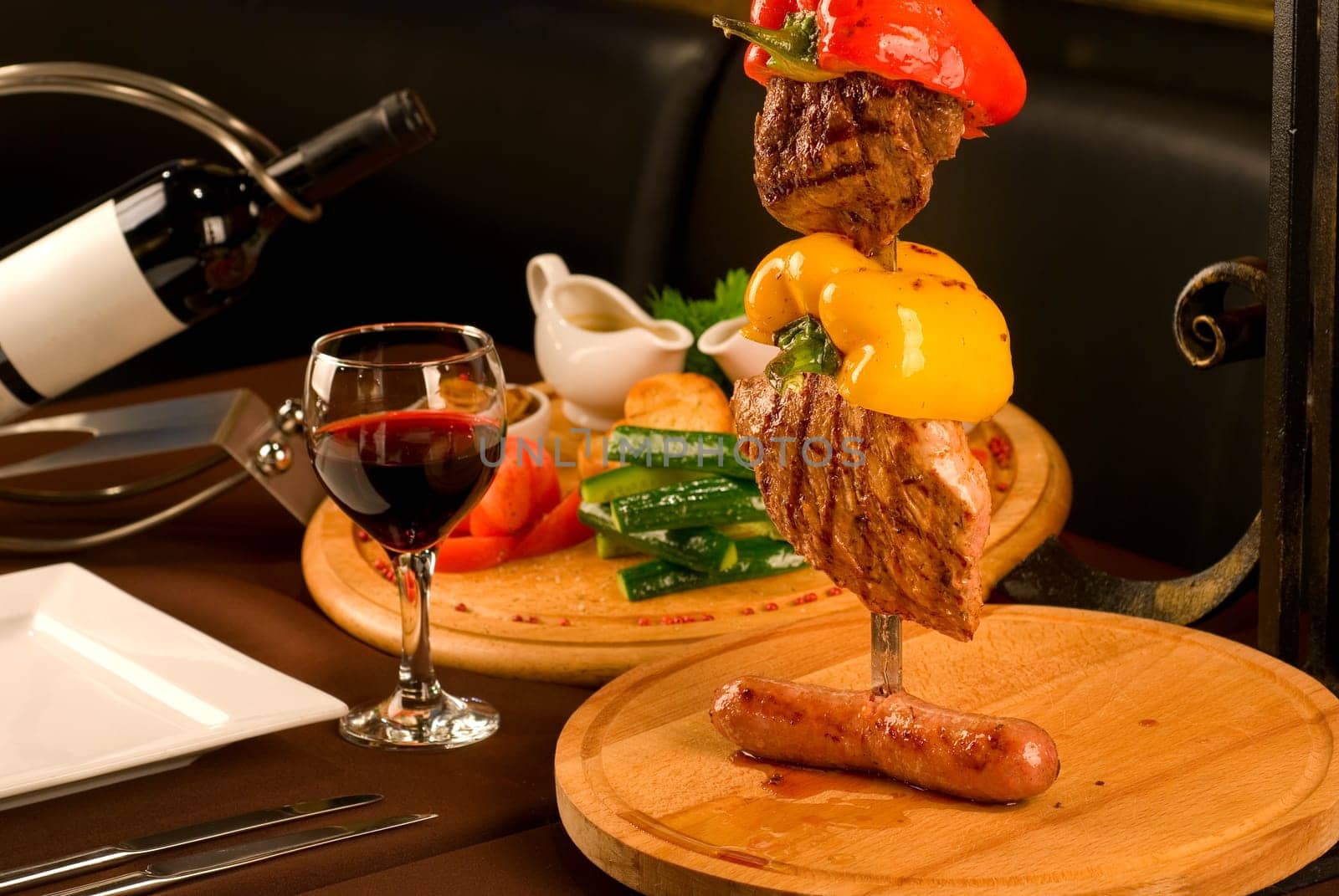 Big tasty roasted meat cuts at skewer on a decorated table