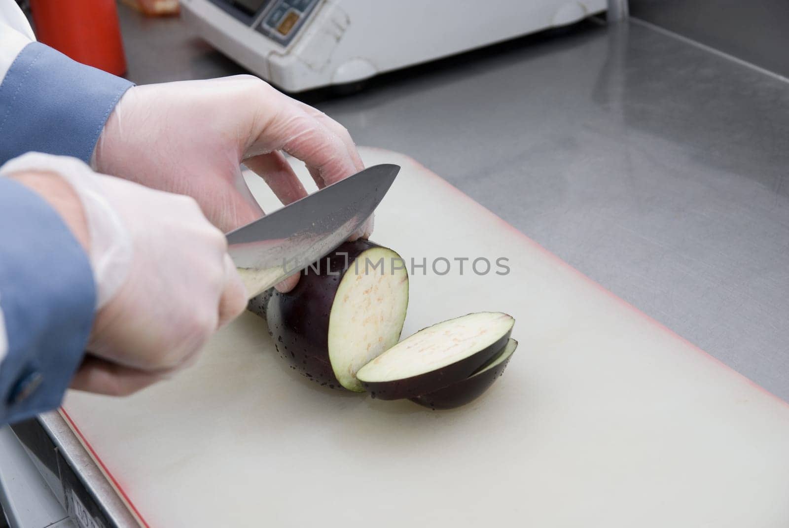 Cook cutting a zucchini at kitchen board