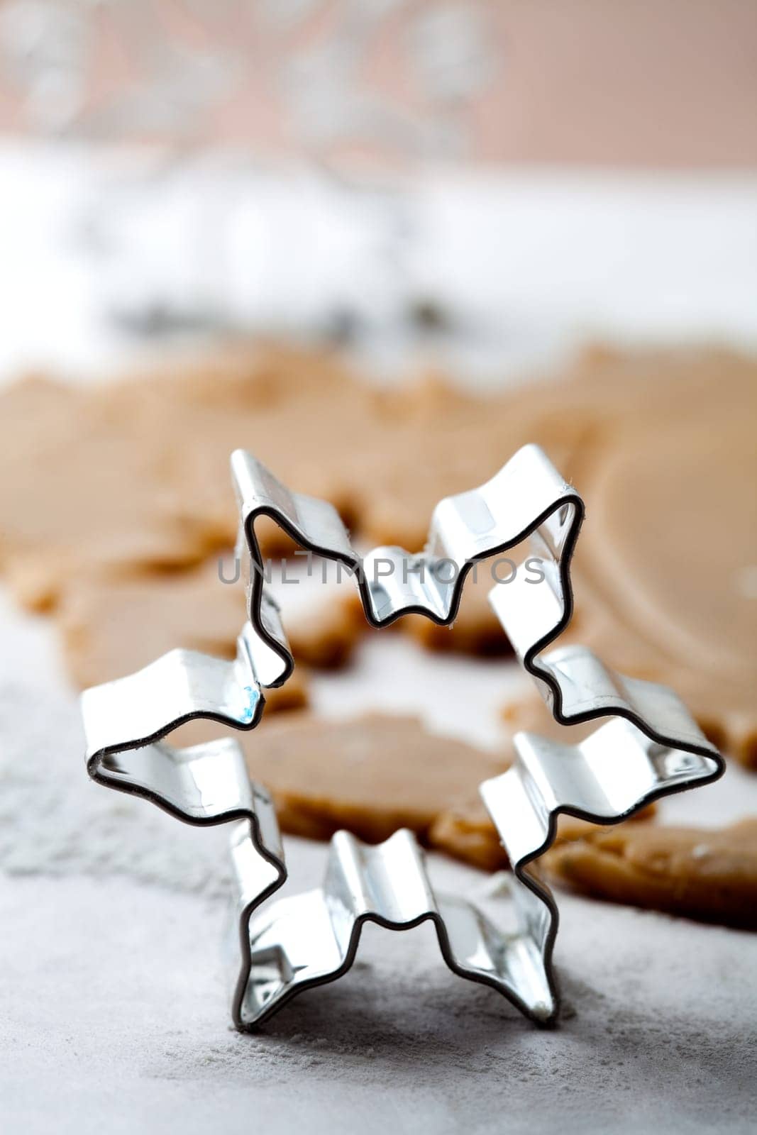 Making gingerbread cookies for Christmas. Gingerbread dough with star shapes and a cutter.