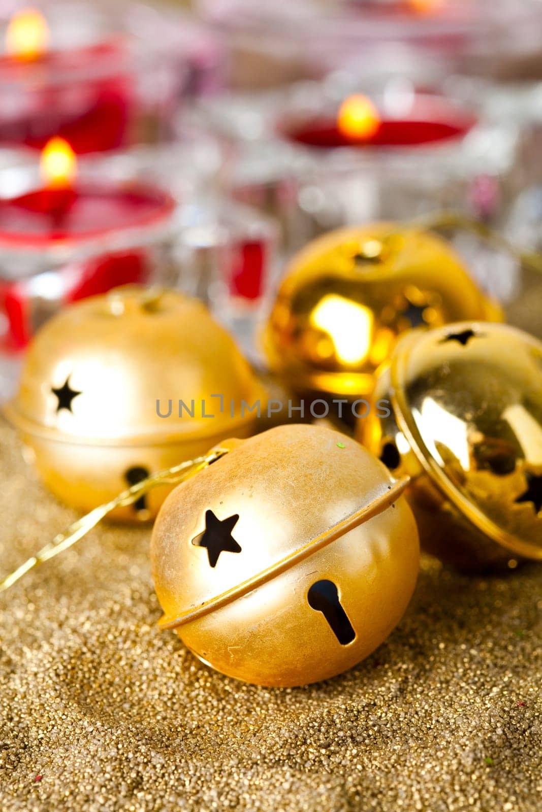 Close-up of golden jingle bell Christmas baubles with candles