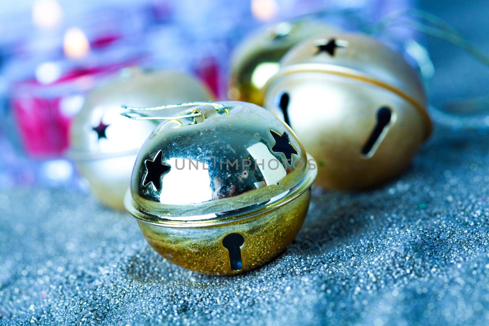 Close-up of golden jingle bell Christmas baubles with candles