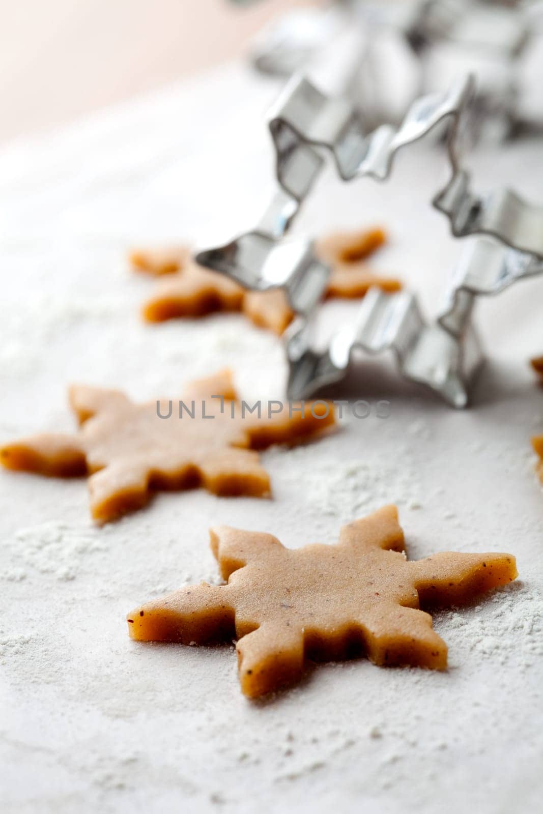 Making gingerbread cookies for Christmas. Gingerbread dough with star shapes and a cutter.