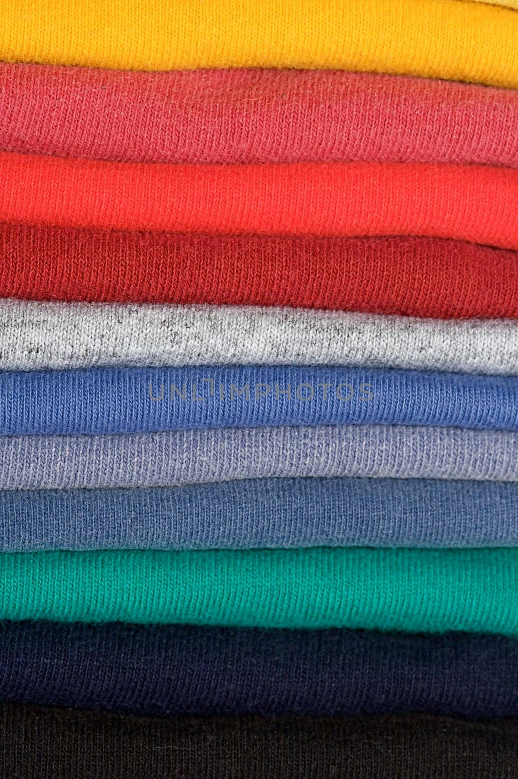 Stack of colored tee shirts on a shelf